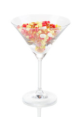 Goblet with pills isolated on white