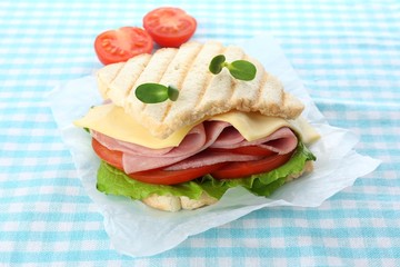 Tasty sandwich with ham on table