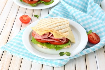 Tasty sandwich with ham on wooden table