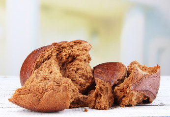 Pieces of bread on table on bright background