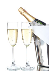 Glasses of champagne and bottle in pail, isolated on white