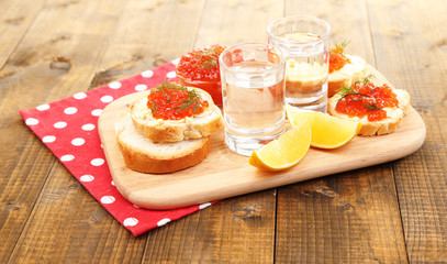 Red caviar in bowl and vodka