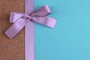 Sackcloth with color ribbon and bow on color paper background