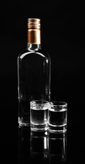 Bottle of vodka  and glasses isolated on black