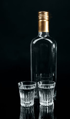 Bottle of vodka  and glasses isolated on black