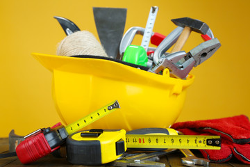Fototapeta premium Construction equipment on wooden table, on color background
