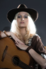 Retro soft focus hippie 70s country guitar girl with long blonde