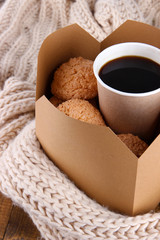 Hot coffee and cookies in box on knitted scarf  close-up