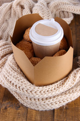 Hot coffee and cookies in box on wooden table close-up