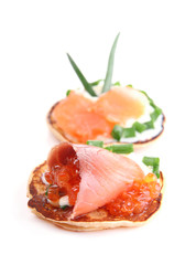 Pancakes with red caviar and salmon,  isolated on white
