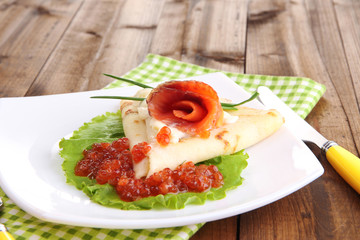 Pancake with salmon, red caviar and mayo, green onion,