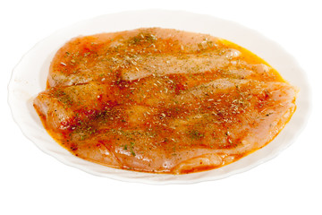 Raw marinated chicken breasts with spices isolated on white