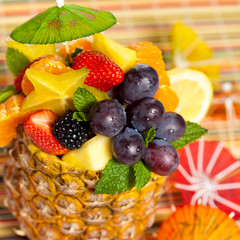 Fototapeta na wymiar Salad of pineapple, oranges and other fruits in a pineapple