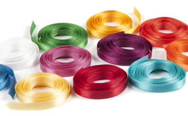 Coiled spools of colorful ribbons on a white background