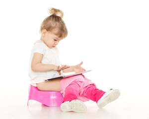 Pretty little girl sits on potty.