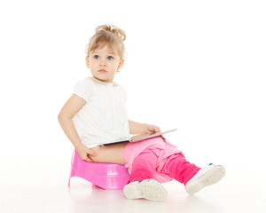 Pretty little girl sits on potty.