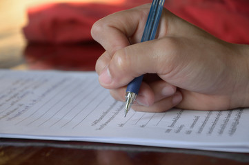 close up of woman hand writing on the paper