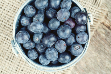 fresh blueberries in a bucket on wooden surface