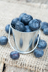 fresh blueberries in a bucket on wooden surface