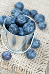 fresh blueberries in a bucket on wooden surface