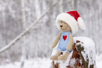 Teddy bear in christmas sitting in the snow
