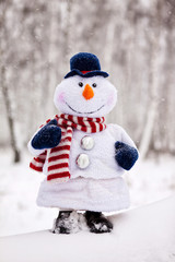 Happy Christmas snowman sitting in a snowy winter