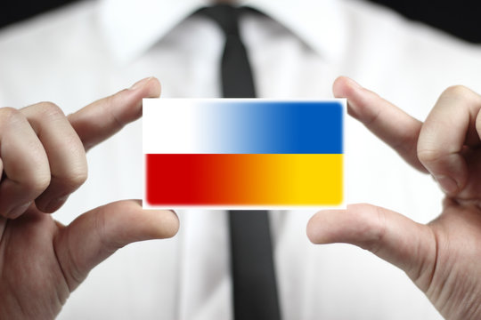 Businessman holding a business card with Poland and Ukraine Flag