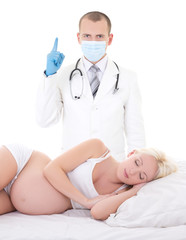 Naklejka premium young male gynecologist and pregnant woman lying in bed isolated