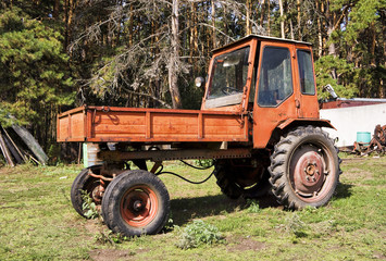 Naklejka premium Old red agriculture tractor in farm