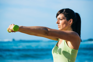 Fitness woman workout with dumbbells outdoor