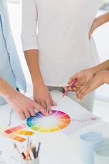 Fototapeta na wymiar Interior designer showing colour wheel to two customers