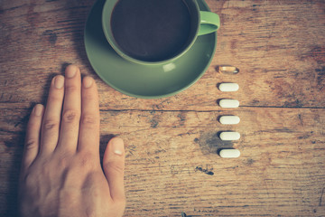 Man having pills and coffee