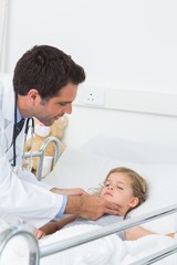 Fototapeta premium Doctor examining thyroid glands of sick girl