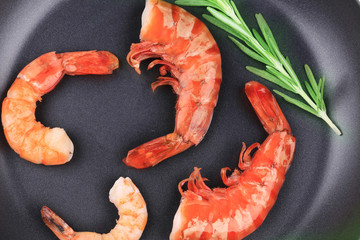 Cooked unshelled shrimps on frying pan.