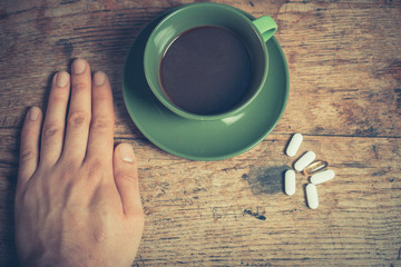 Man having pills and coffee