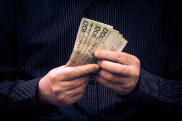 man holds hands Polish money