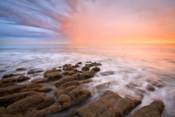 Rain shower lit by worm evening light, Hastings, UK.