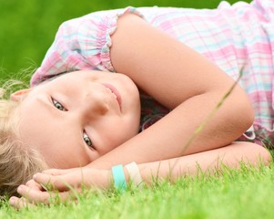 Obraz na płótnie Canvas Young girl lying on the grass.