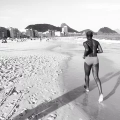 Zelfklevend Fotobehang Man is running on copacabana beach, Rio de Jaineiro, Brazil © Konstantin Naumov