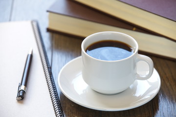 Obraz na płótnie Canvas Coffee break at work Coffee cup on a pile of books