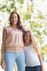 Woman and daughter standing in the park