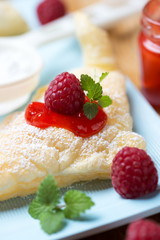 Blätterteigteilchen mit Puderzucker und Himbeeren