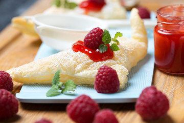Blätterteigteilchen mit Puderzucker und Himbeeren