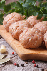 raw meatballs on a chopping board vertical