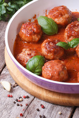 hot meatballs with tomato sauce and basil in a pan