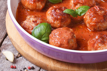 meatballs with tomato sauce and basil in a pan macro