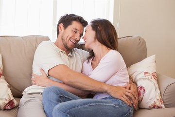 Loving young couple sitting on couch
