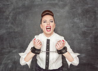 Screaming business woman with handcuffs on her hands