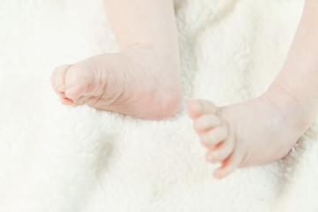 Little baby feet naked in a bed