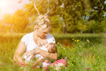 Mutter beim Stillen von  Baby auf Wiese